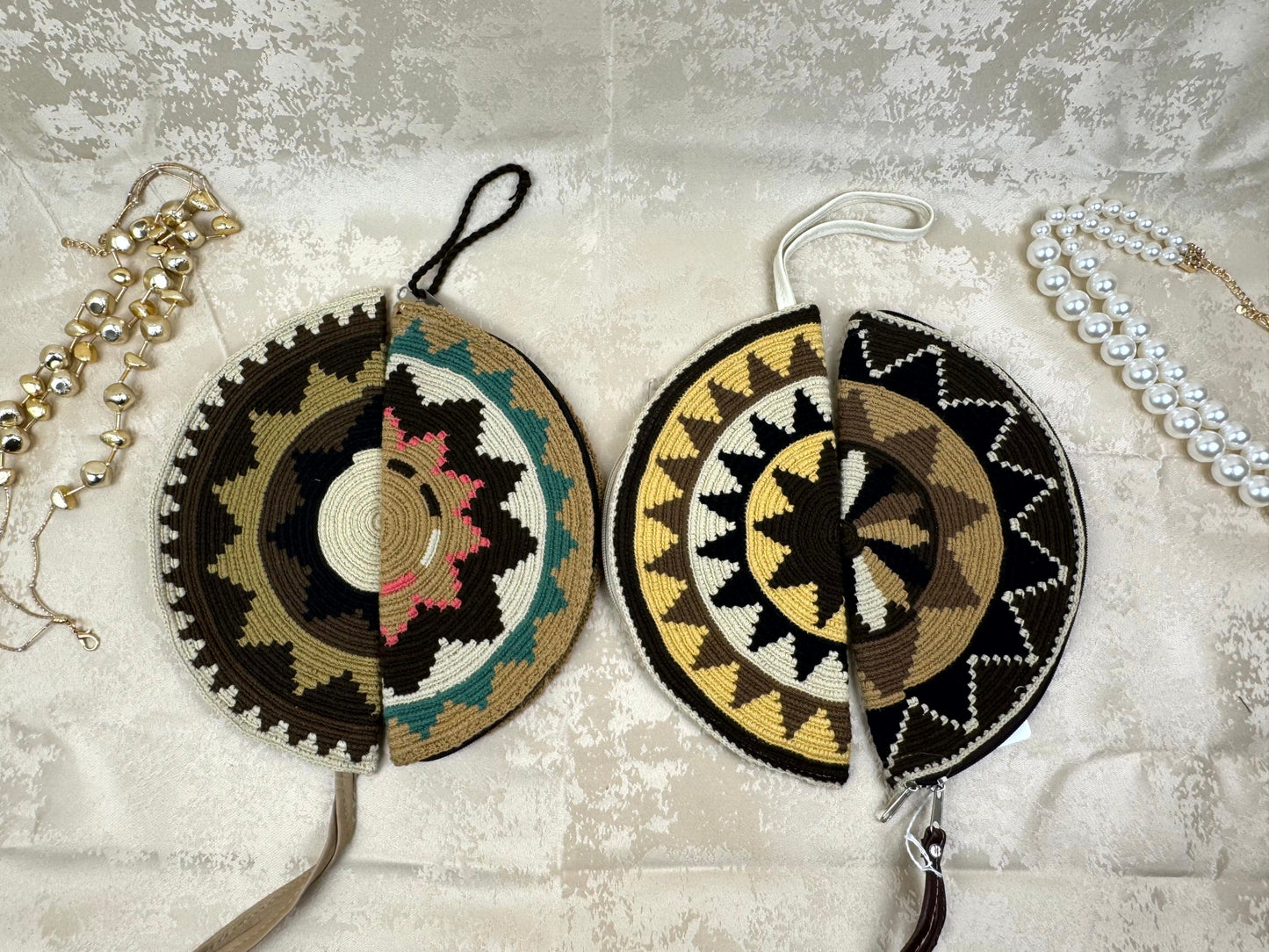 Two decorative circular bags with intricate patterns on a textured surface.