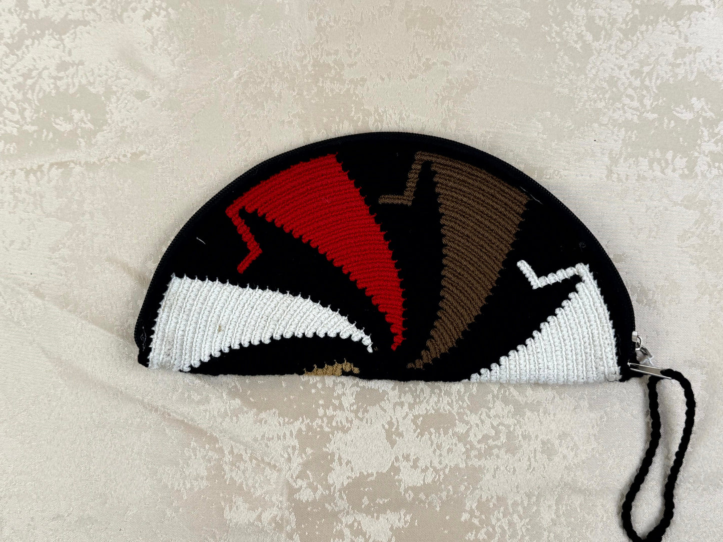 Knitted pouch with geometric pattern on a textured surface