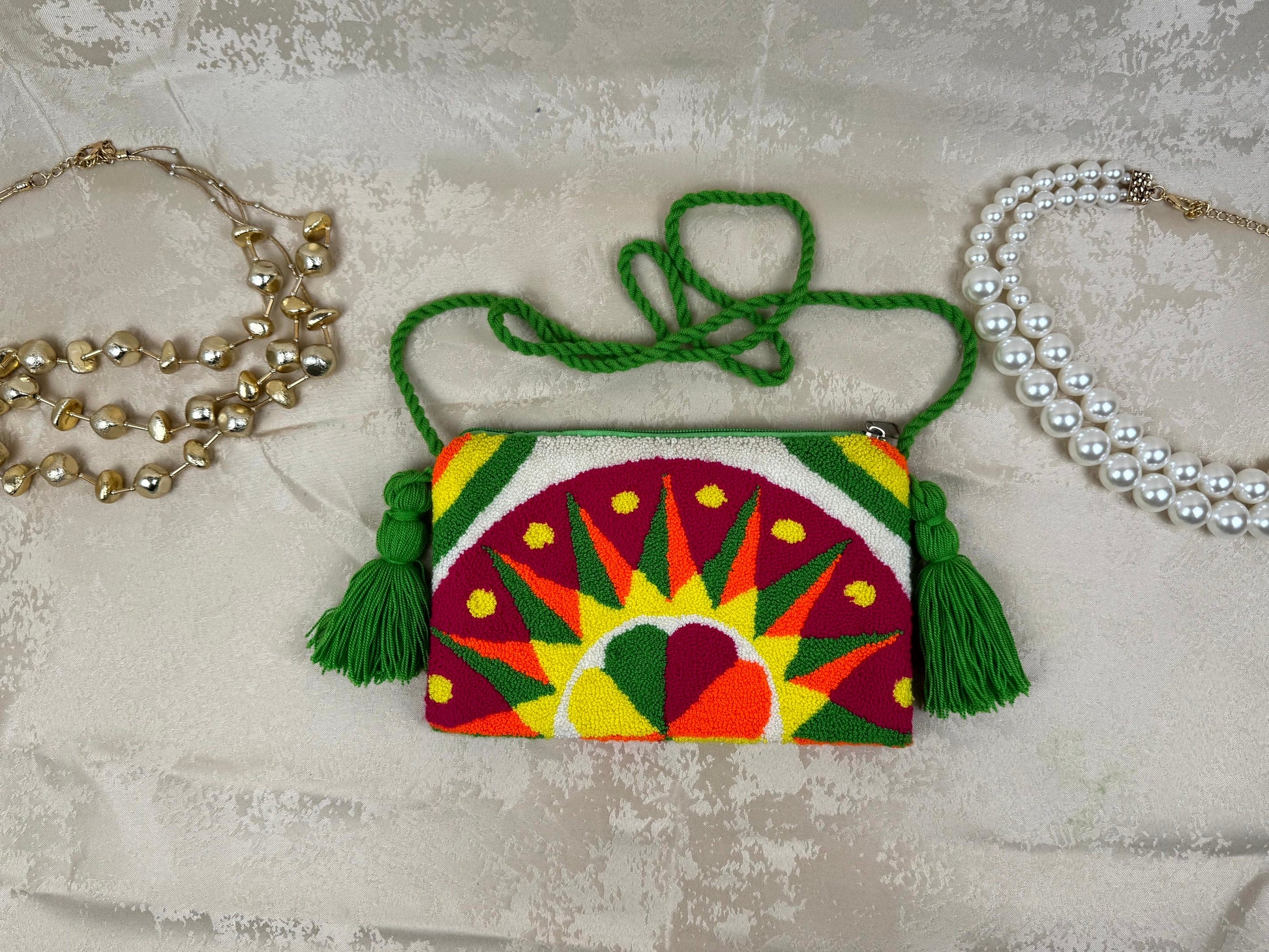Colorful embroidered handbag with tassels on a textured surface