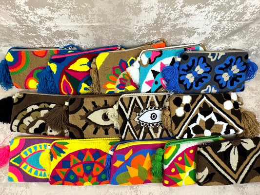 Colorful patterned pouches with tassels on a textured surface