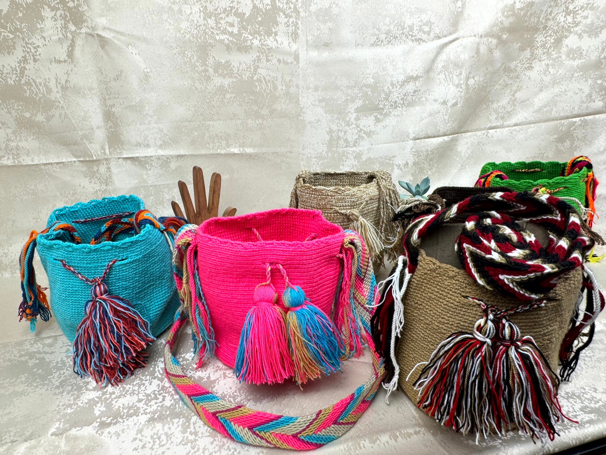 Colorful woven bags with tassels on a textured surface
