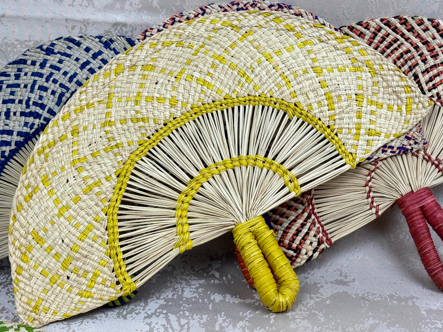 Abanico artesanal de iraca tejido a mano por artesanas colombianas con fibra natural de palma.
