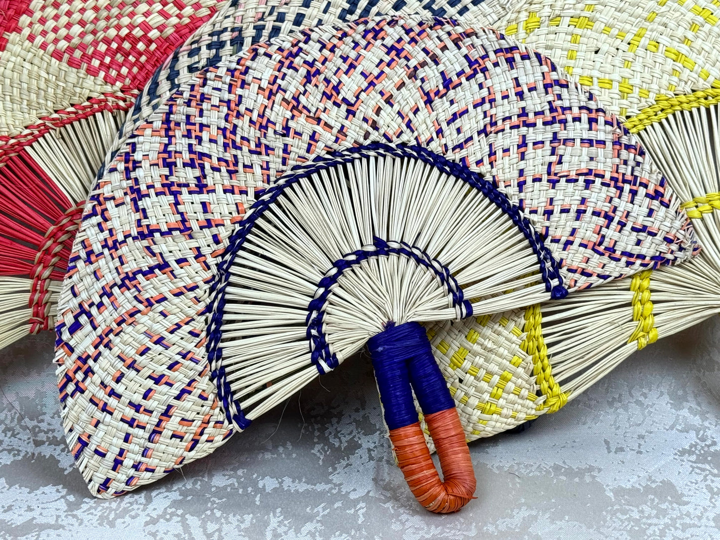 Abanico artesanal de iraca tejido a mano por artesanas colombianas con fibra natural de palma.