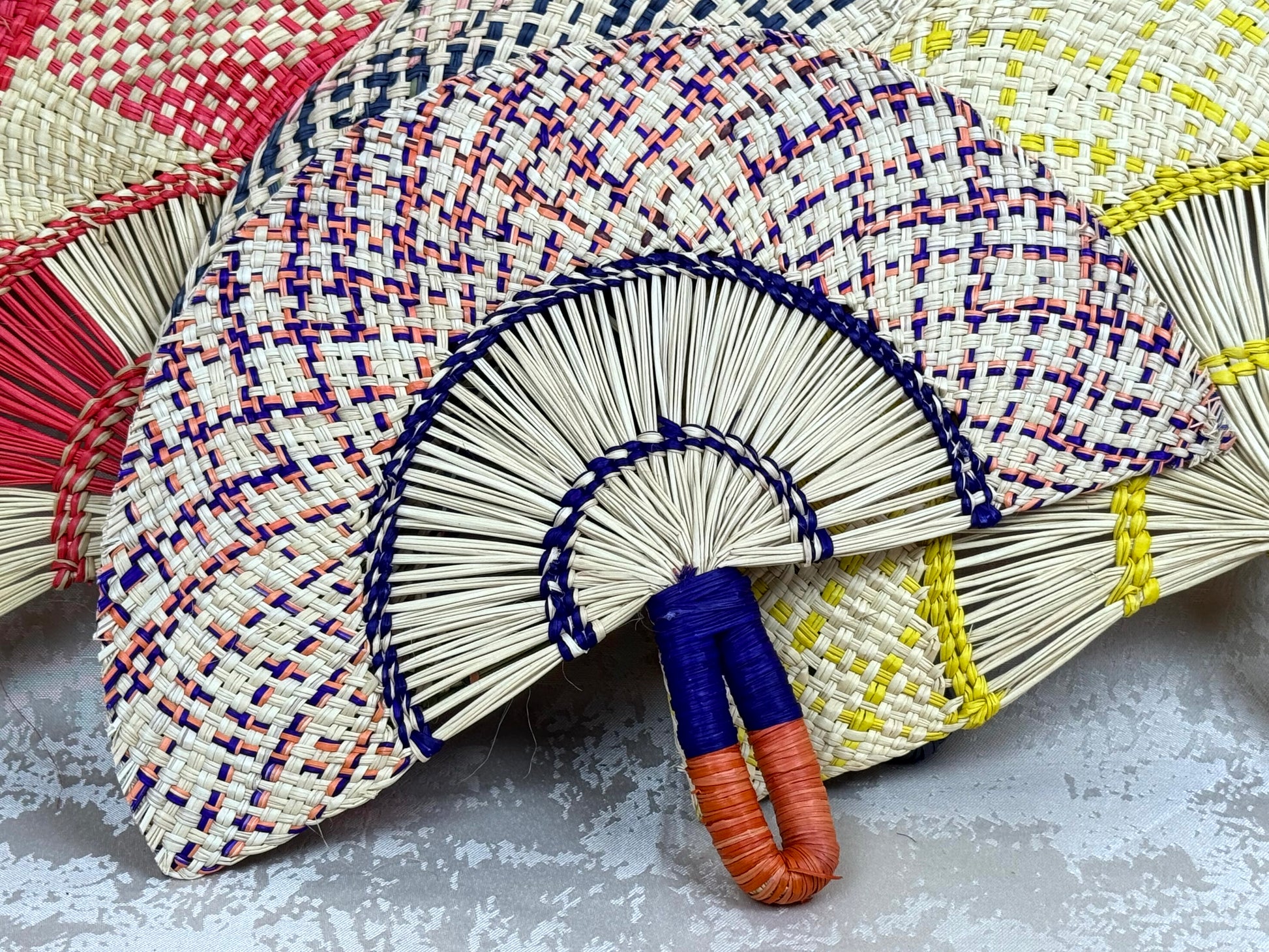 Abanico artesanal de iraca tejido a mano por artesanas colombianas con fibra natural de palma.