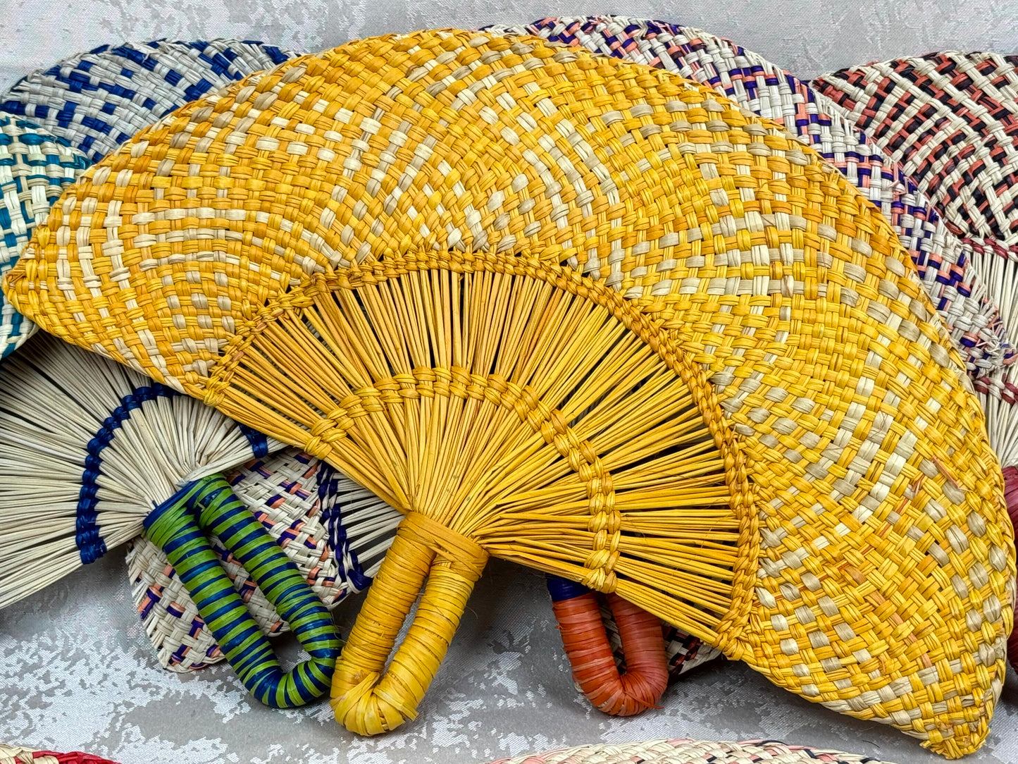 Abanico artesanal de iraca tejido a mano por artesanas colombianas con fibra natural de palma.
