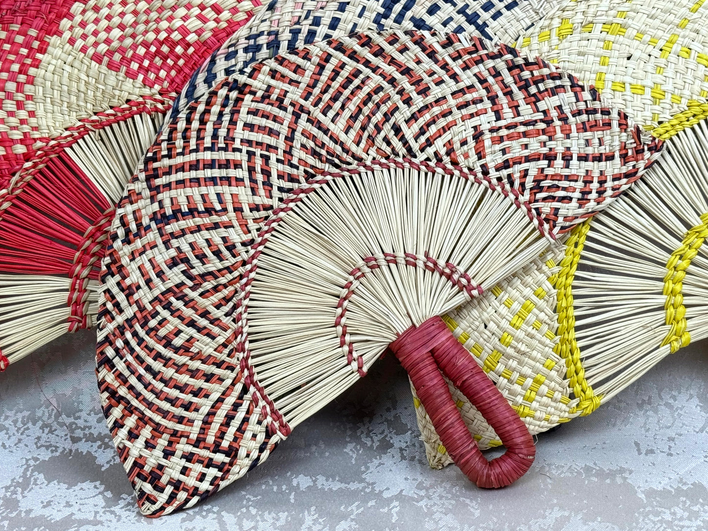 Abanico artesanal de iraca tejido a mano por artesanas colombianas con fibra natural de palma.