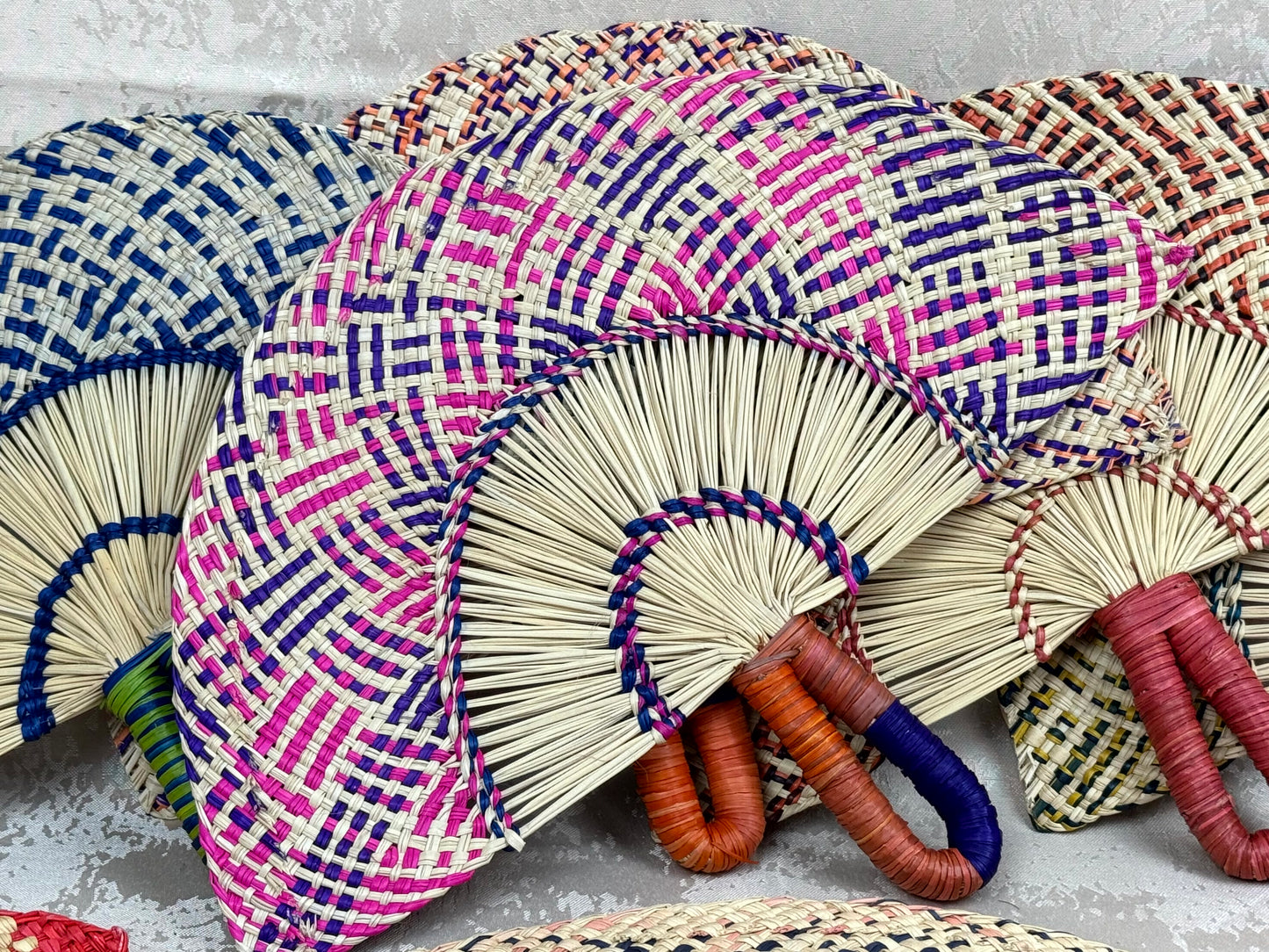 Abanico artesanal de iraca tejido a mano por artesanas colombianas con fibra natural de palma.