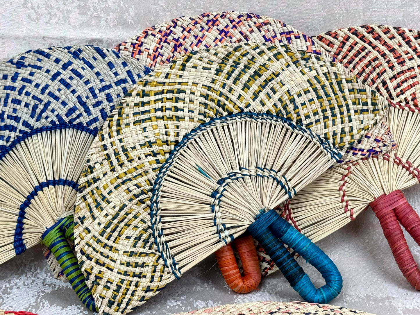 Abanico artesanal de iraca tejido a mano por artesanas colombianas con fibra natural de palma.