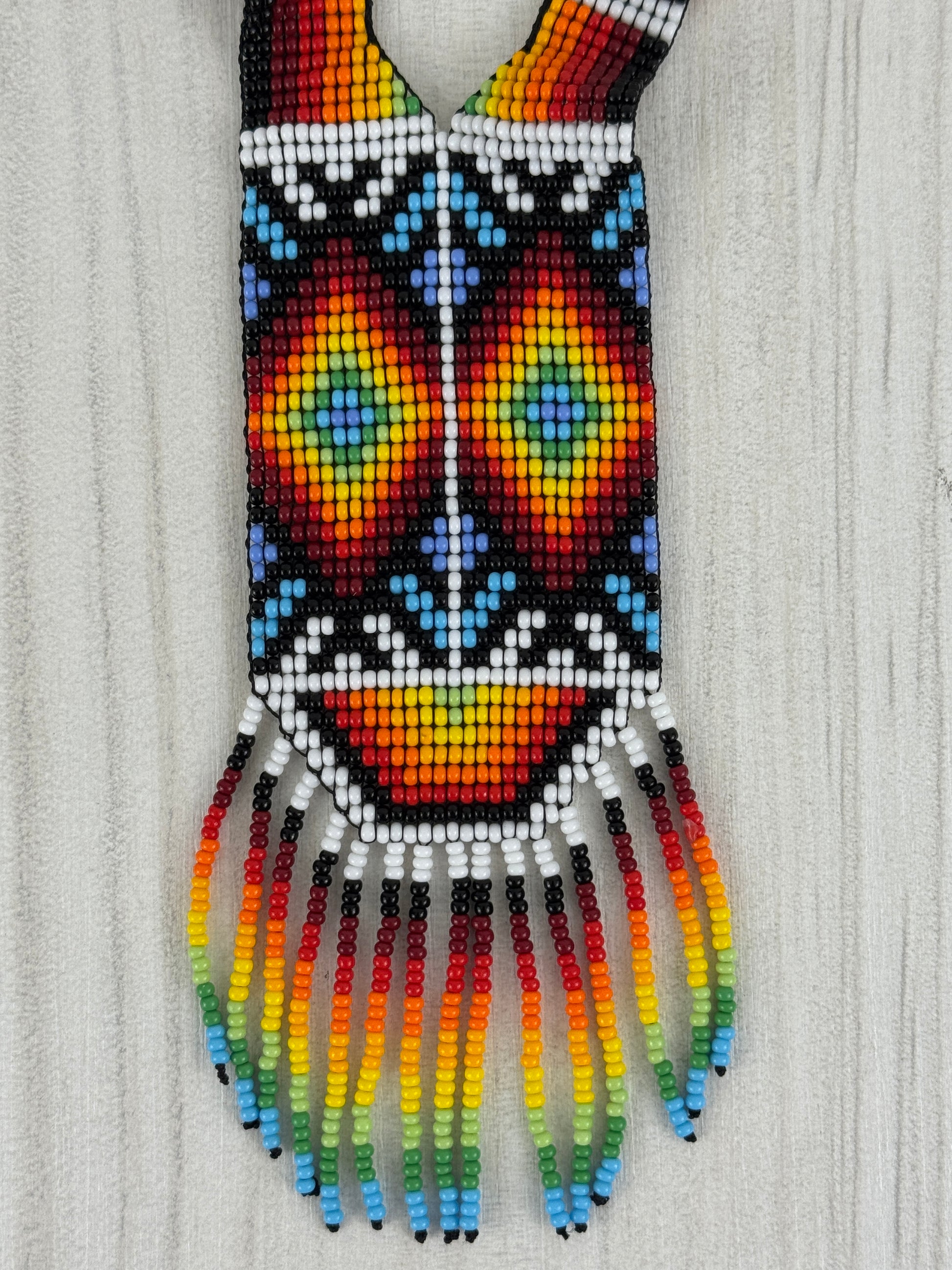 Vista frontal de collar ceremonial artesanal tamaño medio con diseño tradicional tejido a mano.