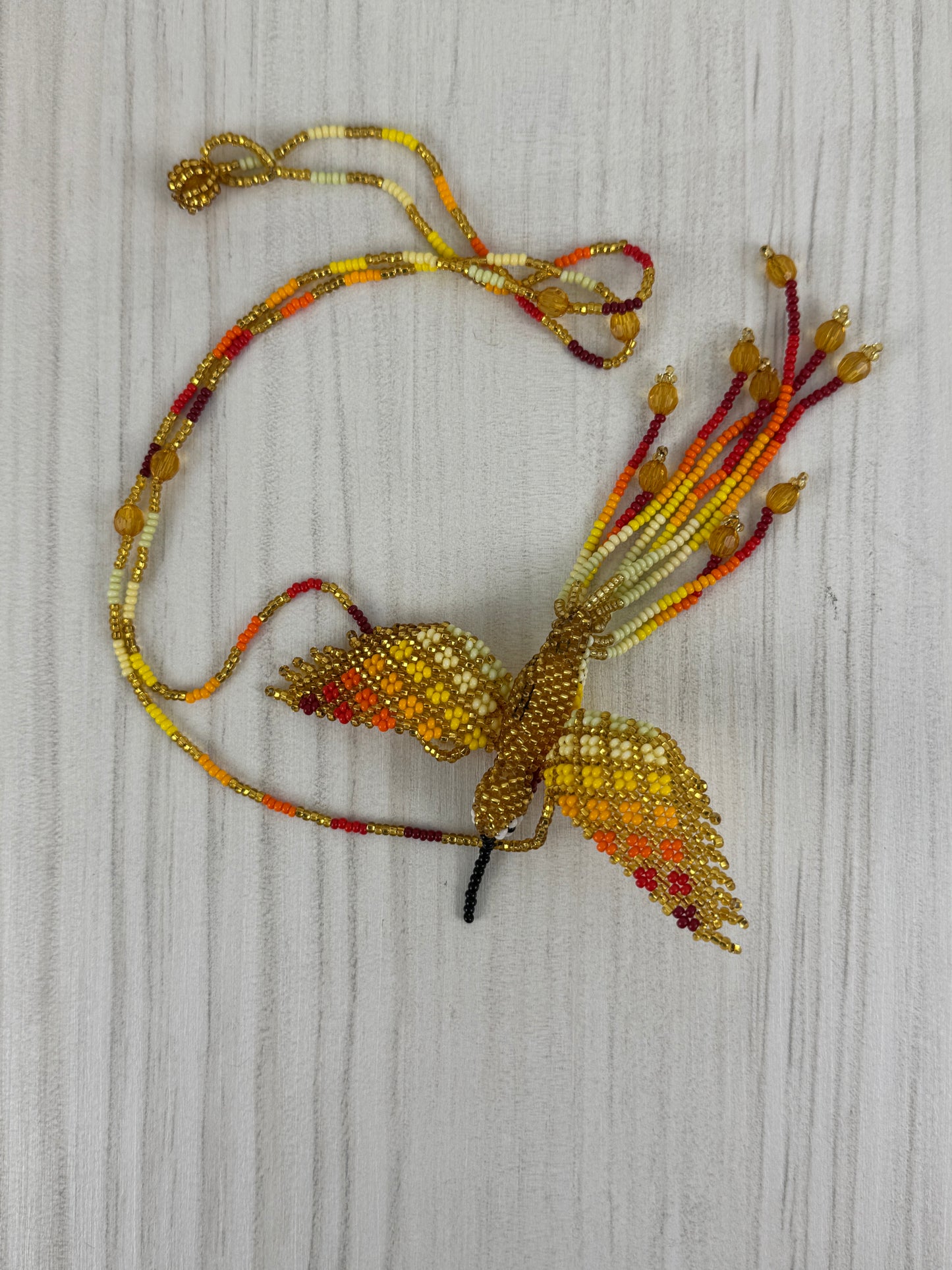 Collar pájaro colibri amarillo tejido a mano edición limitada elaborado artesanalmente por artesanos latinoamericanos.