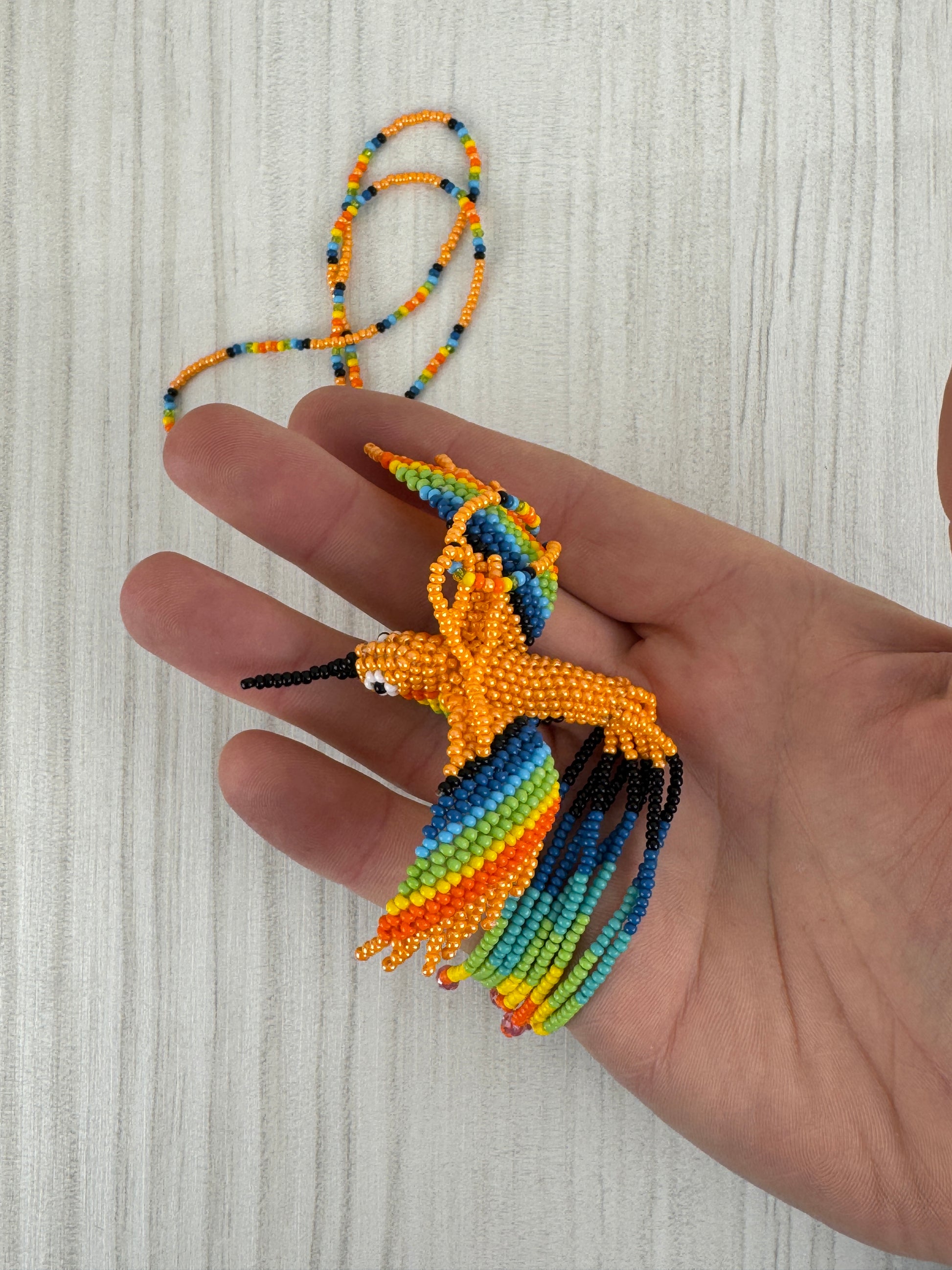 Collar pájaro colibri melocoton tejido a mano edición limitada elaborado artesanalmente por artesanos latinoamericanos.