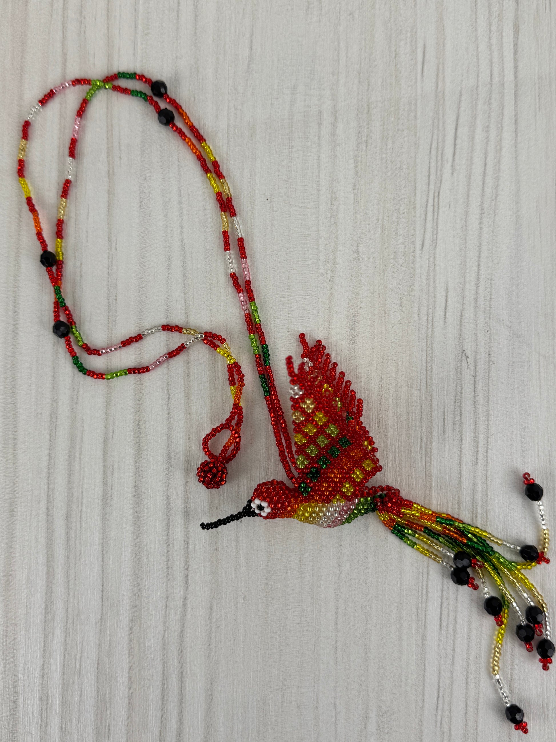 Collar pájaro tejido a mano edición limitada elaborado artesanalmente por artesanos latinoamericanos.