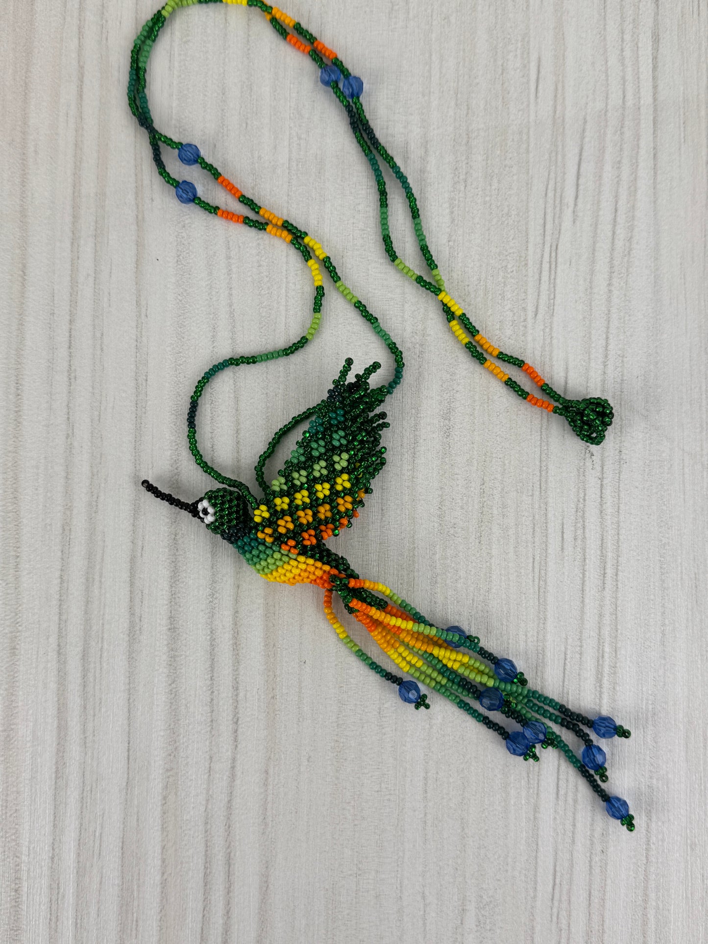 Collar pájaro colibri verde tejido a mano edición limitada elaborado artesanalmente por artesanos latinoamericanos.