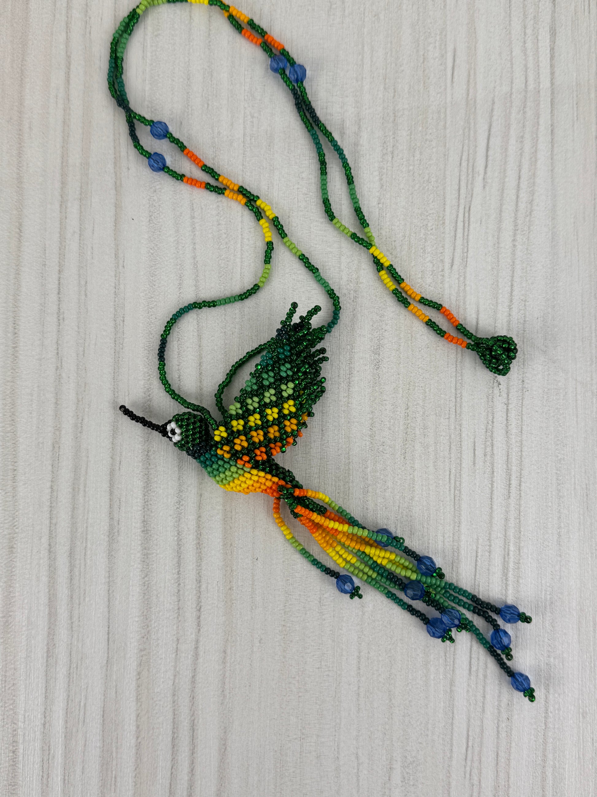 Collar pájaro colibri verde tejido a mano edición limitada elaborado artesanalmente por artesanos latinoamericanos.