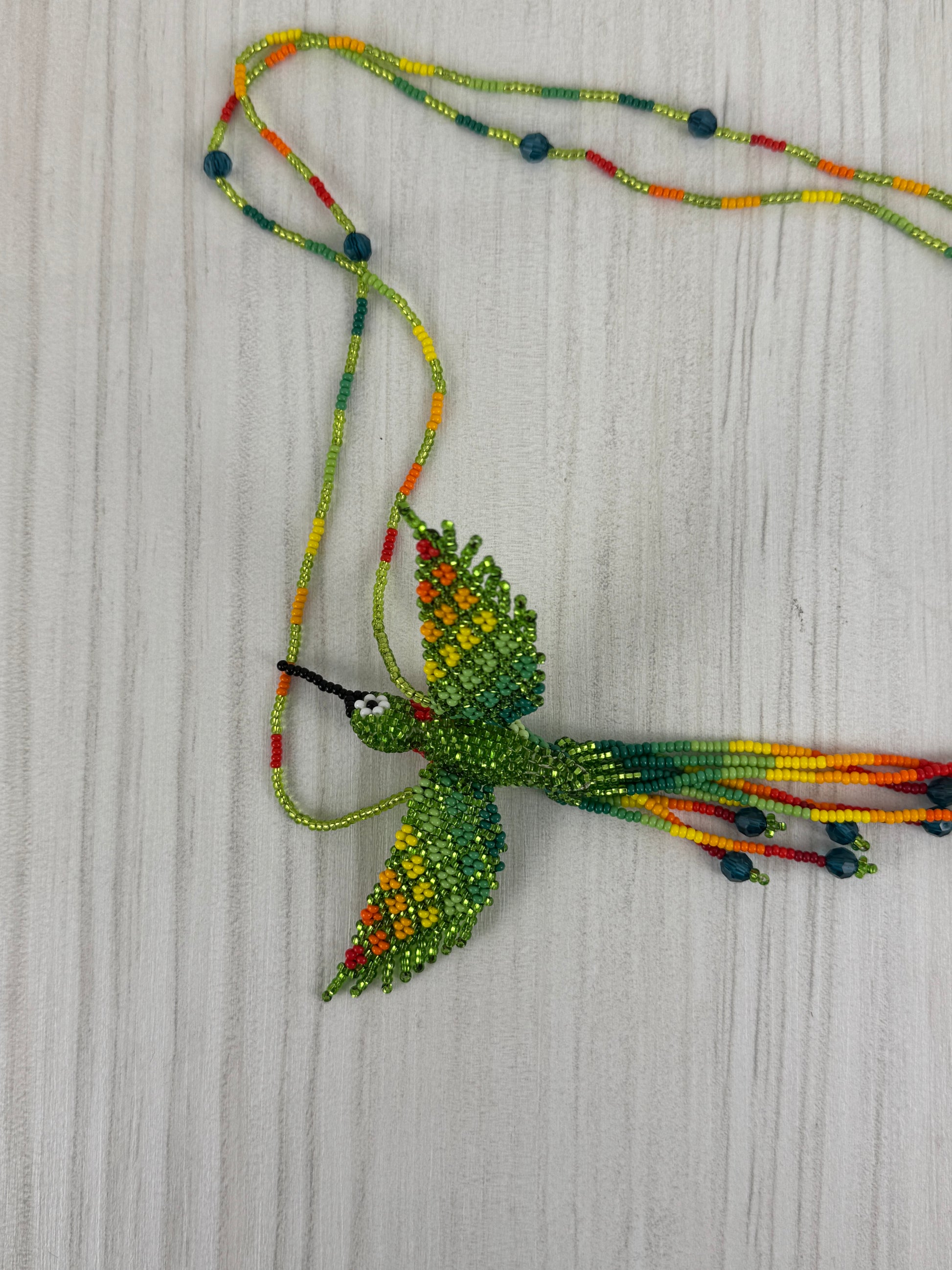 Collar pájaro tejido a mano edición limitada elaborado artesanalmente por artesanos latinoamericanos.