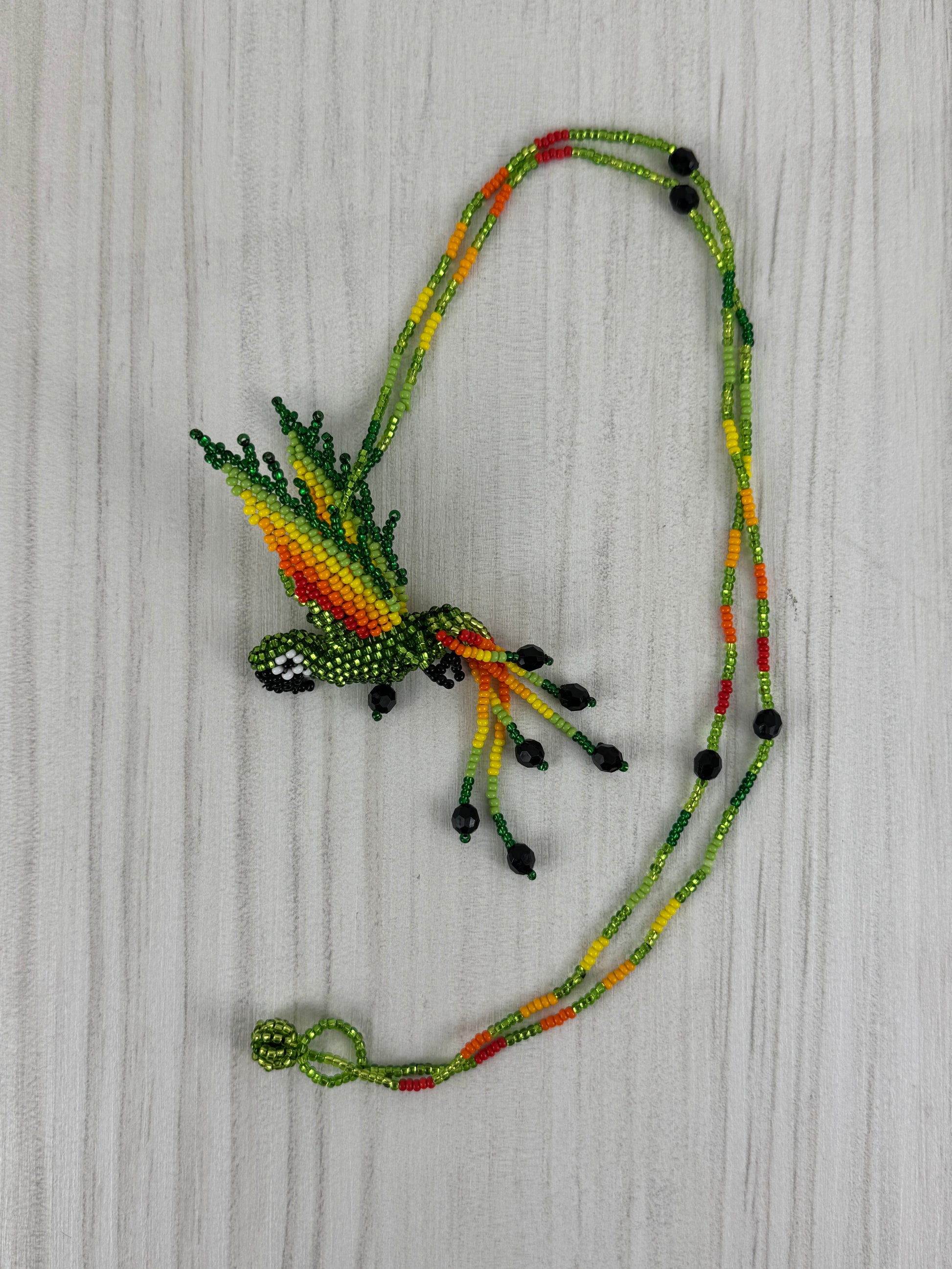 Collar pájaro lloro tejido a mano edición limitada elaborado artesanalmente por artesanos latinoamericanos.