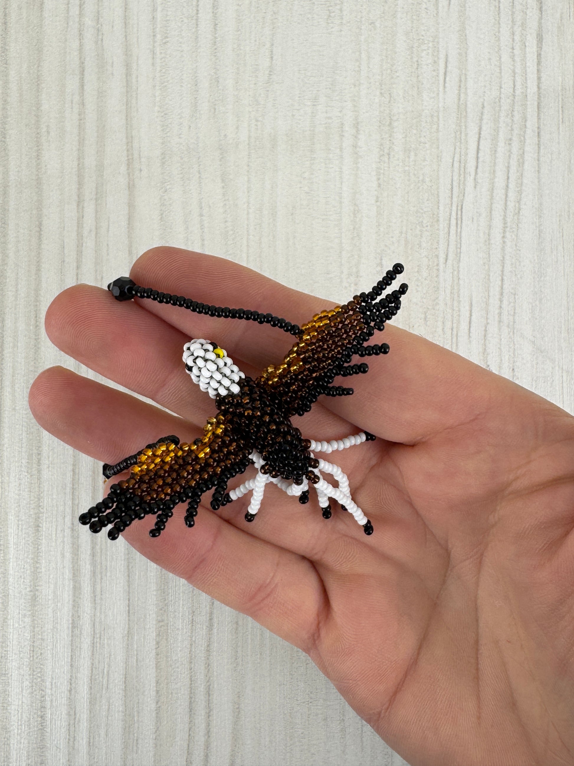 Detalle del pájaro aguila tejido a mano en collar artesanal edición limitada.