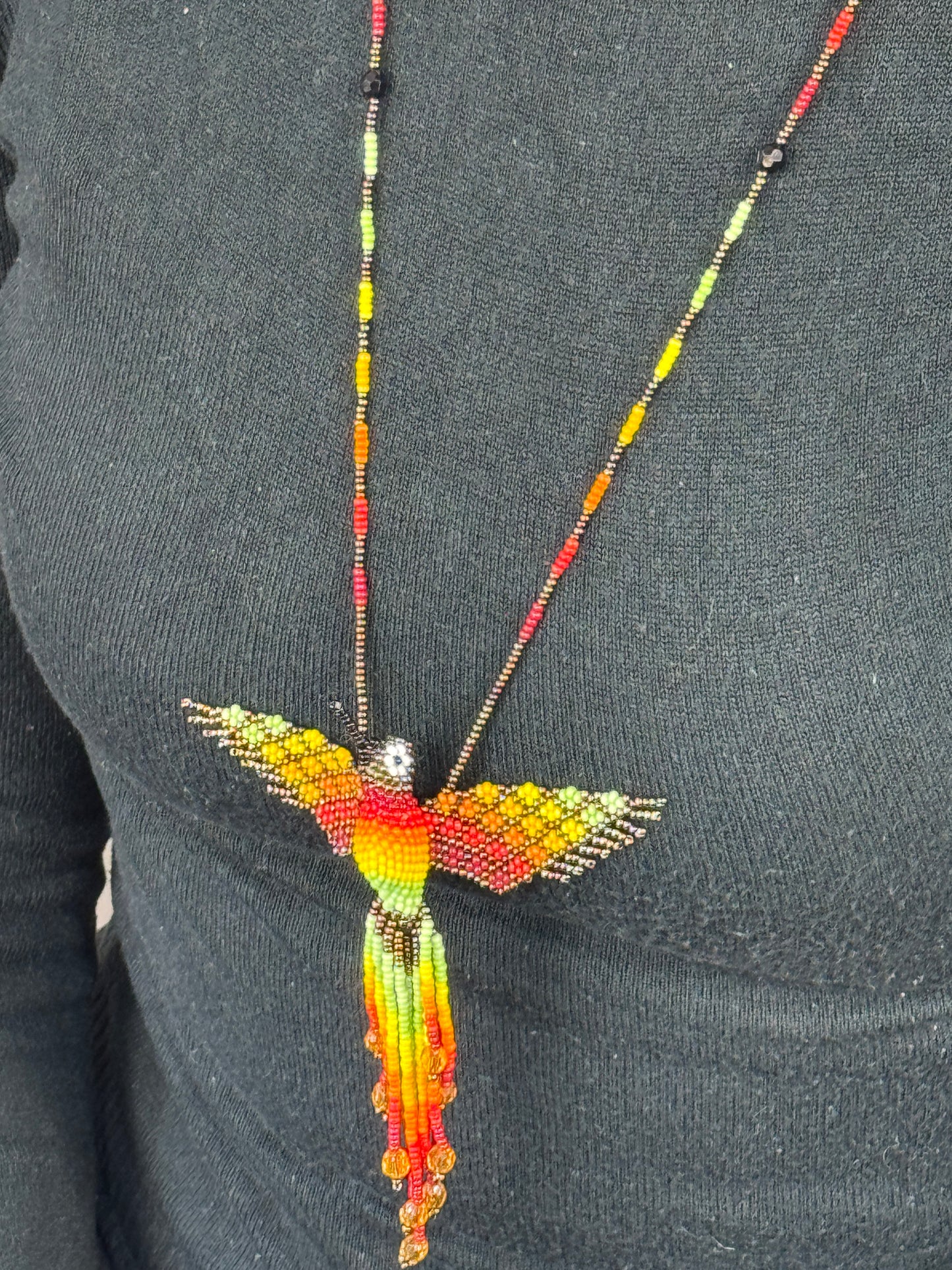 Detalle del tejido artesanal en collar pájaro colibri marron hecho a mano.