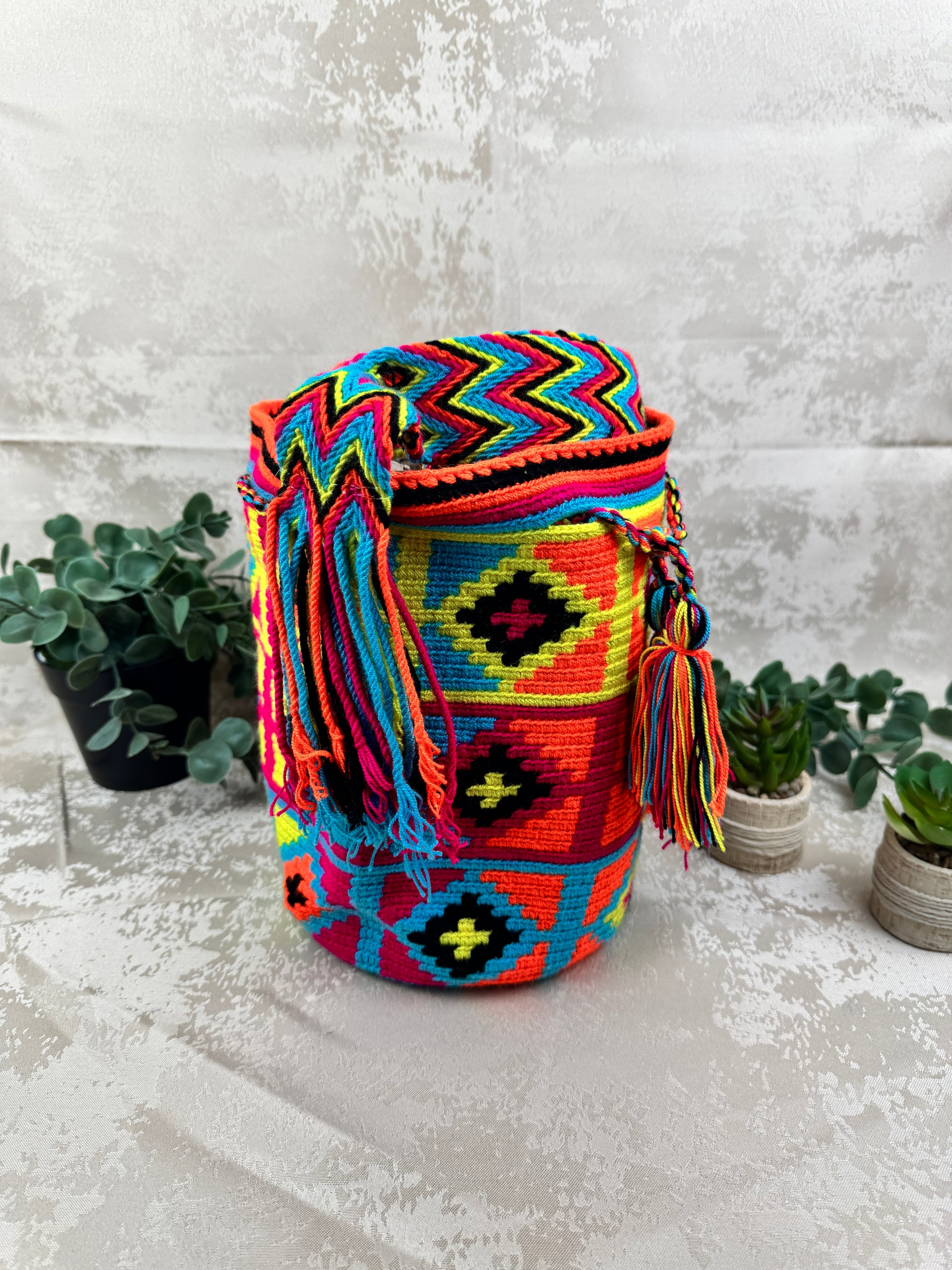 Vista lateral de mochila Wayuu mediana artesanal tejida en Colombia.