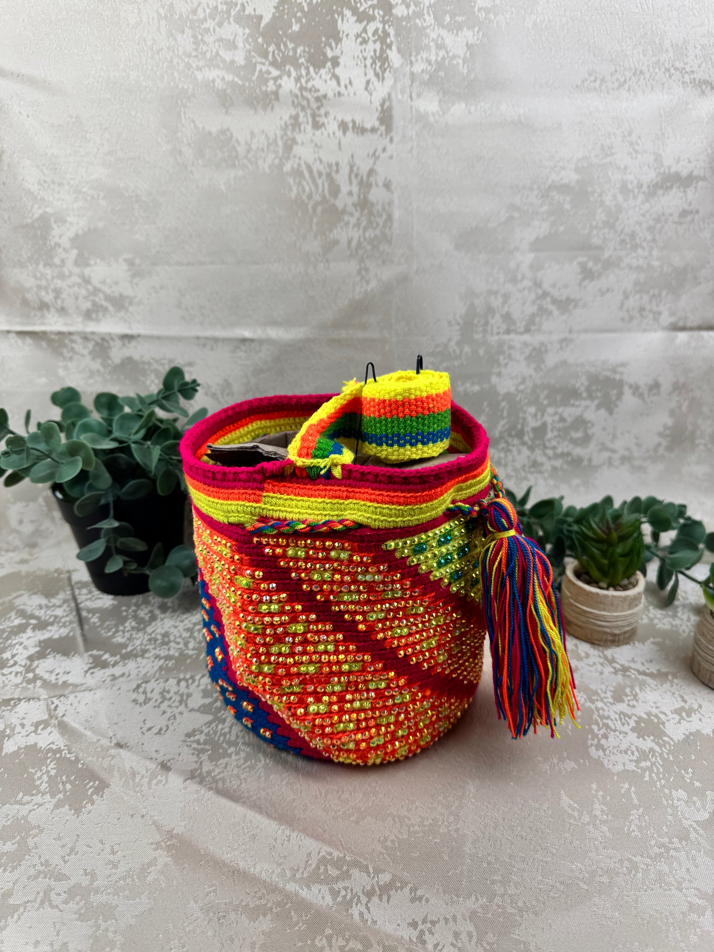 Vista lateral de mochila Wayuu mediana con piedras brillantes tejida artesanalmente en Colombia.