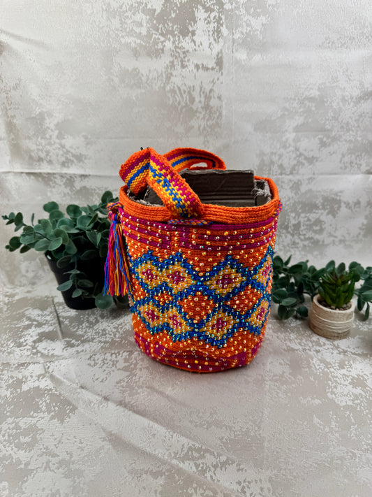 Vista frontal de mochila Wayuu mediana con piedras brillantes y diseño tradicional tejido a mano.