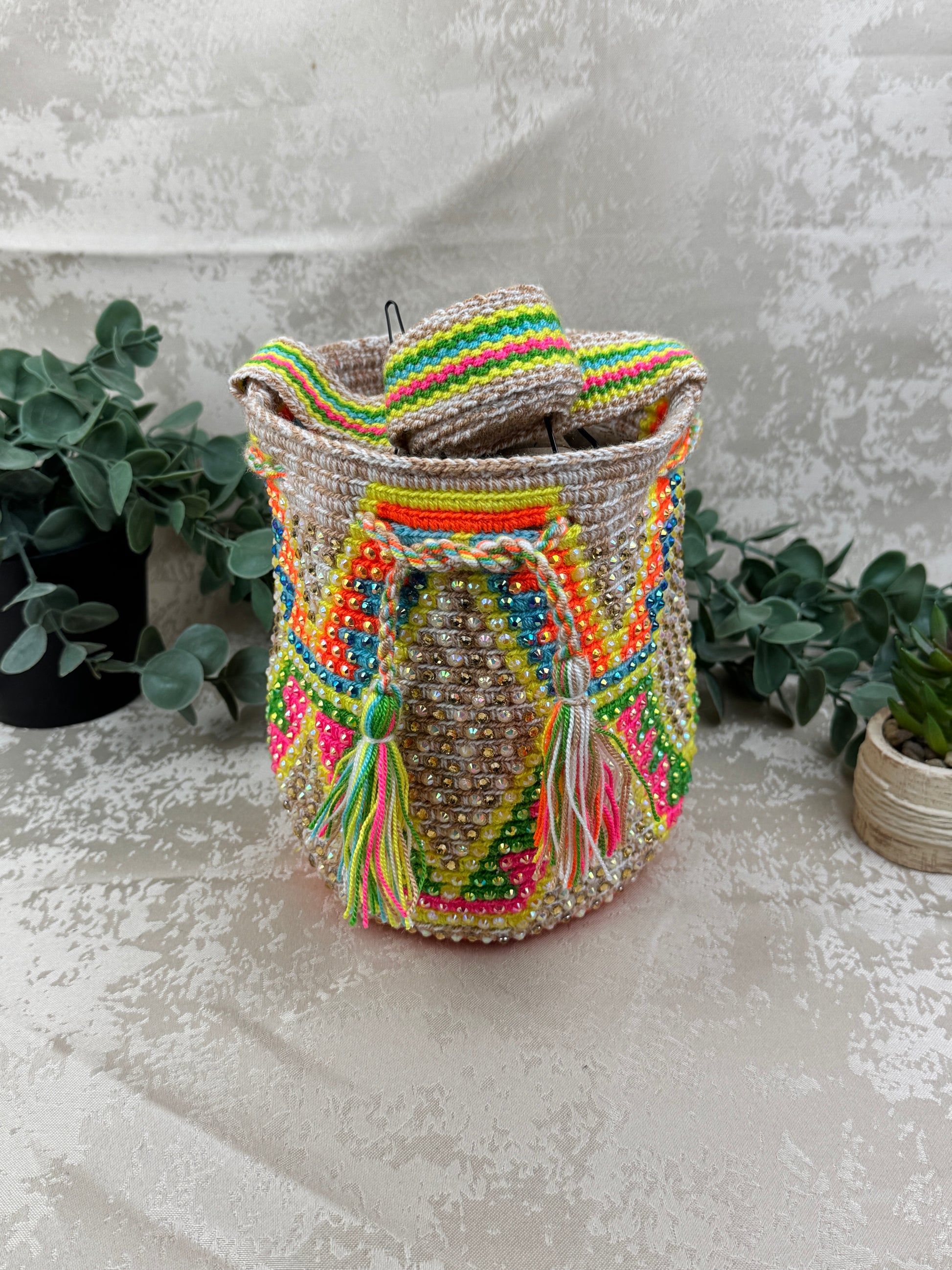 Vista frontal de mochila Wayuu Susuchón edición brillante 10 con piedras decorativas.