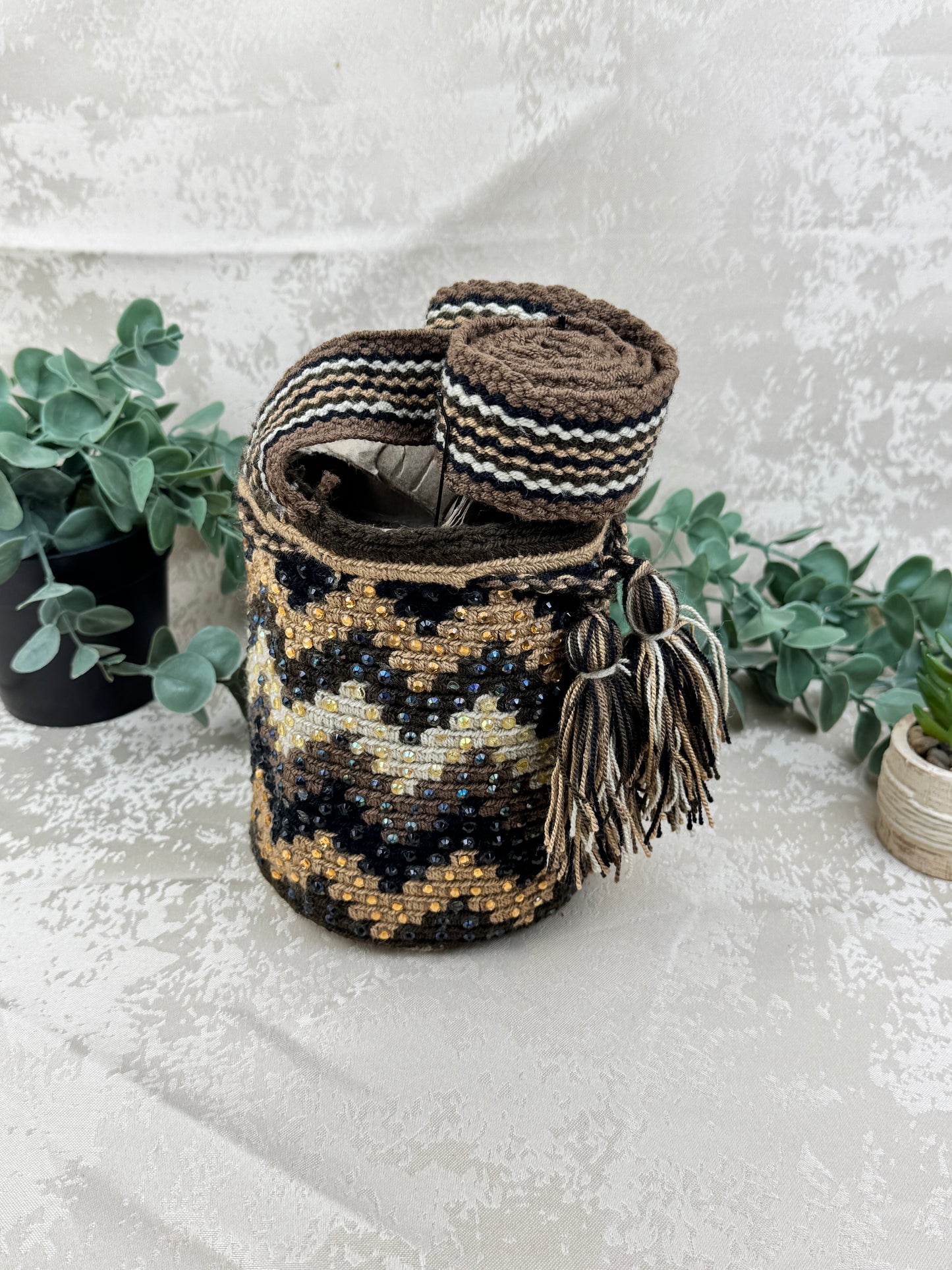 Vista frontal de mochila Wayuu Susuchón edición brillante 13 con piedras decorativas.