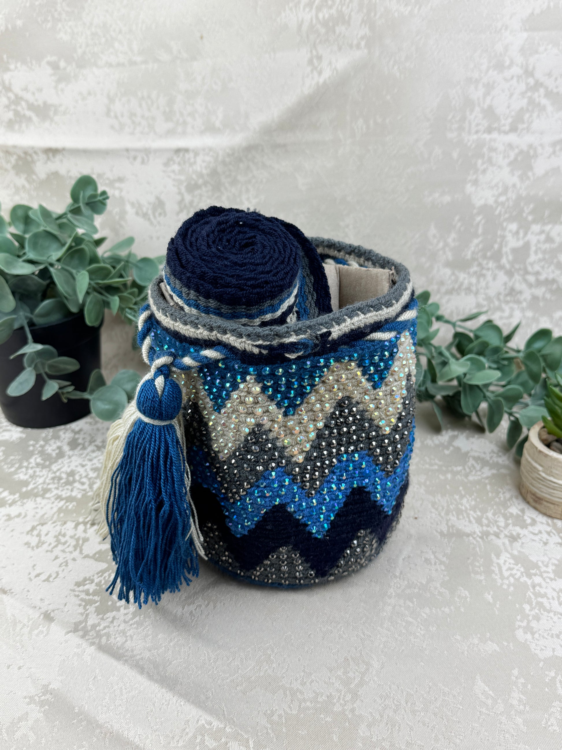 ALT: Correa tejida artesanalmente en mochila Wayuu Susuchón edición brillante.