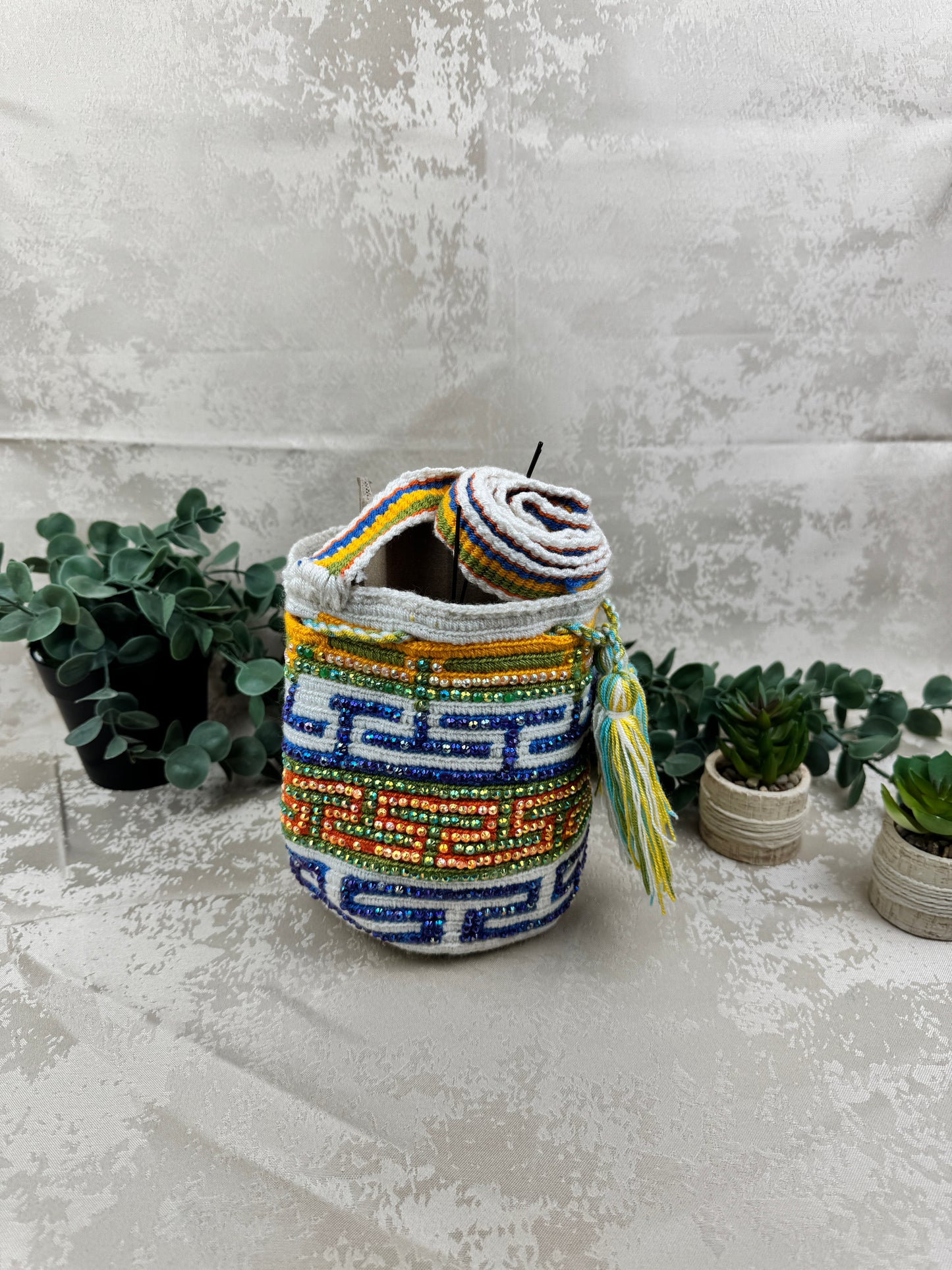 Vista frontal de mochila Wayuu Susuchón edición brillante 18 con piedras decorativas.