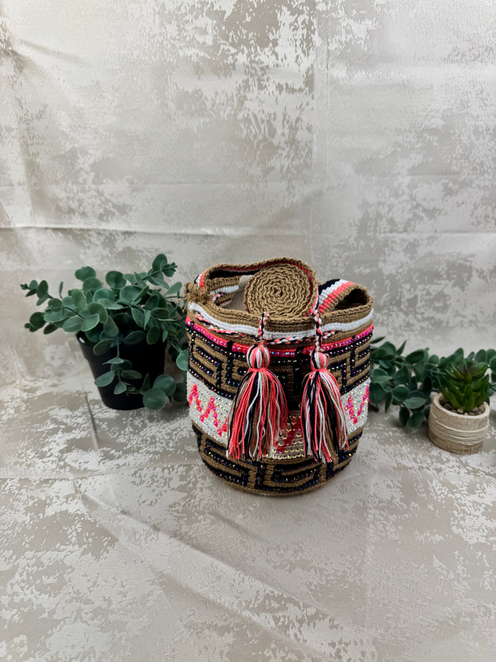 Vista frontal de mochila Wayuu Susuchón edición brillante 19 con piedras decorativas.