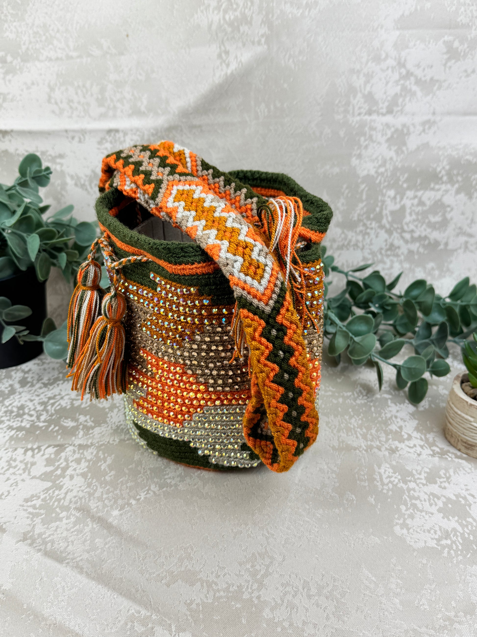 Vista frontal de mochila Wayuu Susuchón edición brillante 3 con piedras decorativas y tejido artesanal.