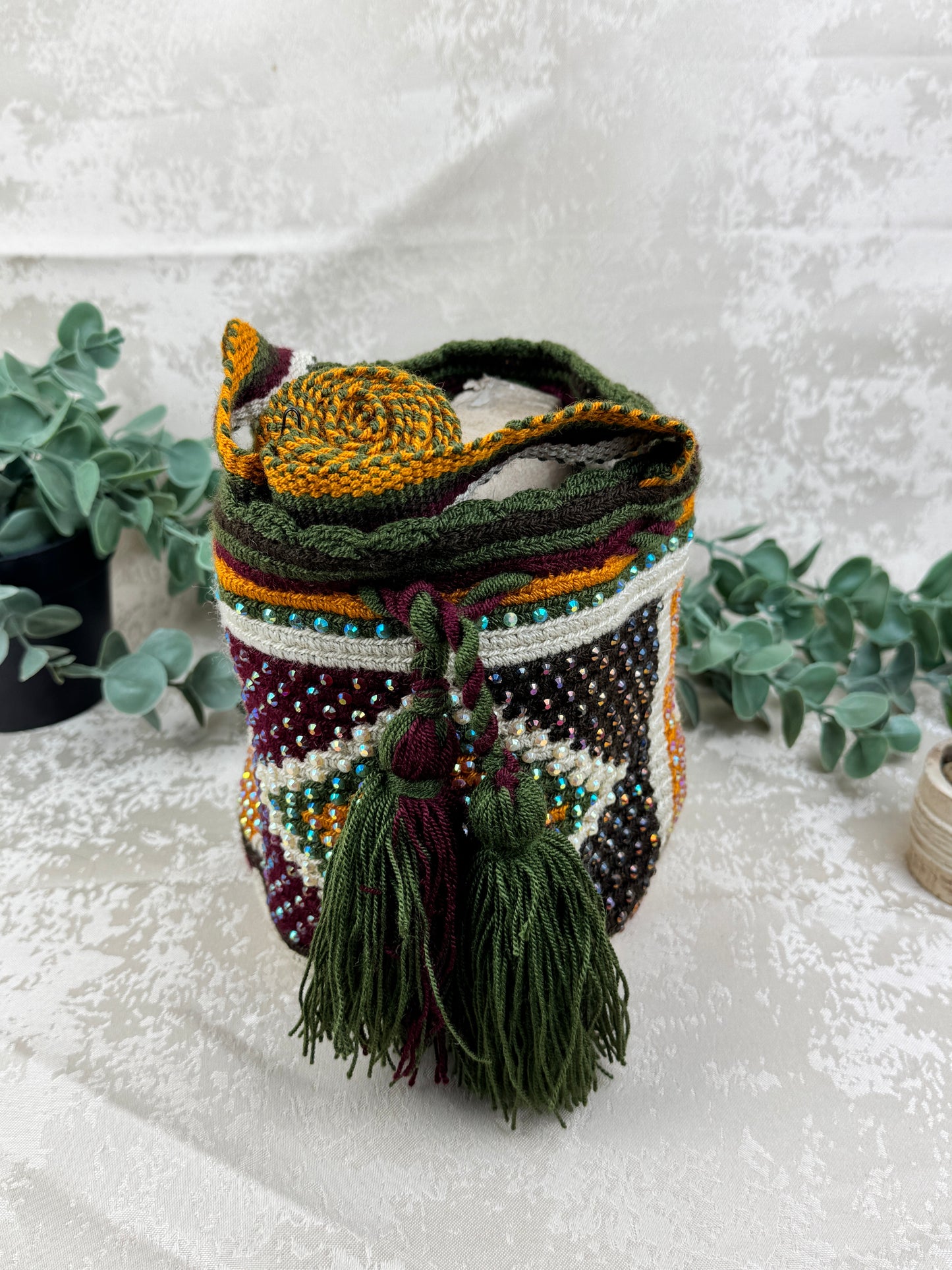 Vista frontal de mochila Wayuu Susuchón edición brillante 4 con piedras decorativas y tejido artesanal.