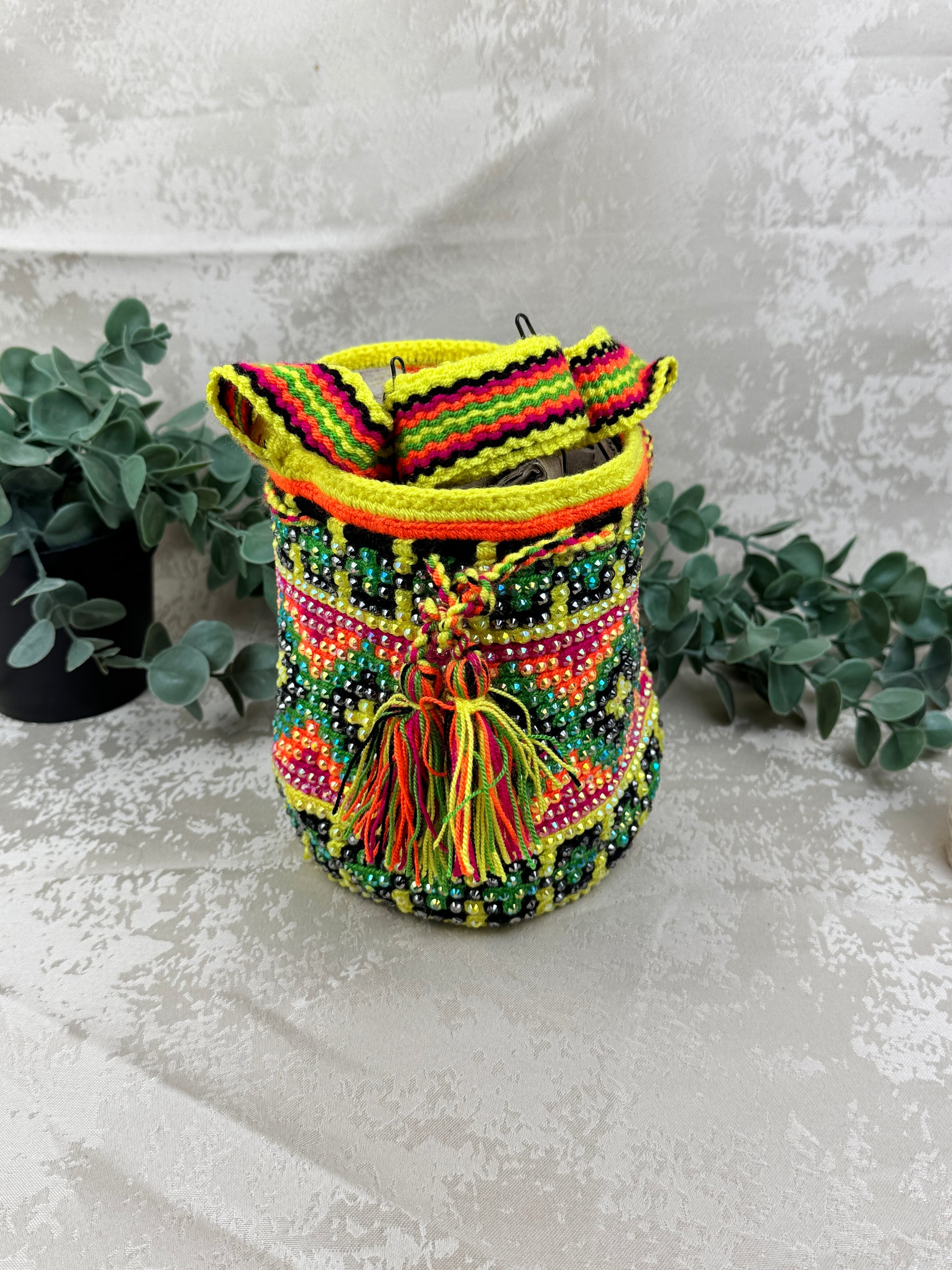 Vista frontal de mochila Wayuu Susuchón edición brillante 5 con piedras decorativas y tejido artesanal.