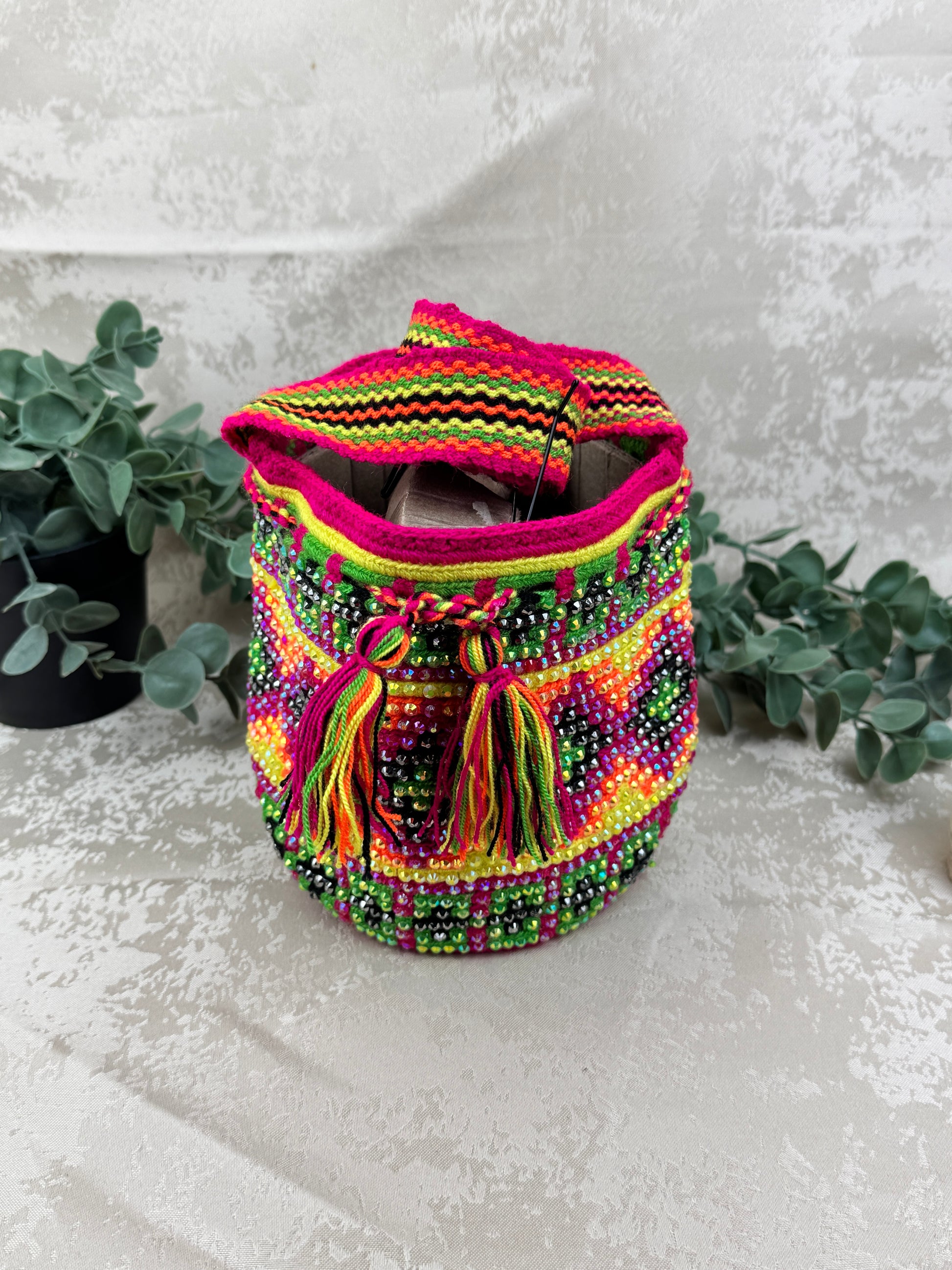 Vista lateral de mochila Wayuu Susuchón artesanal con piedras brillantes.