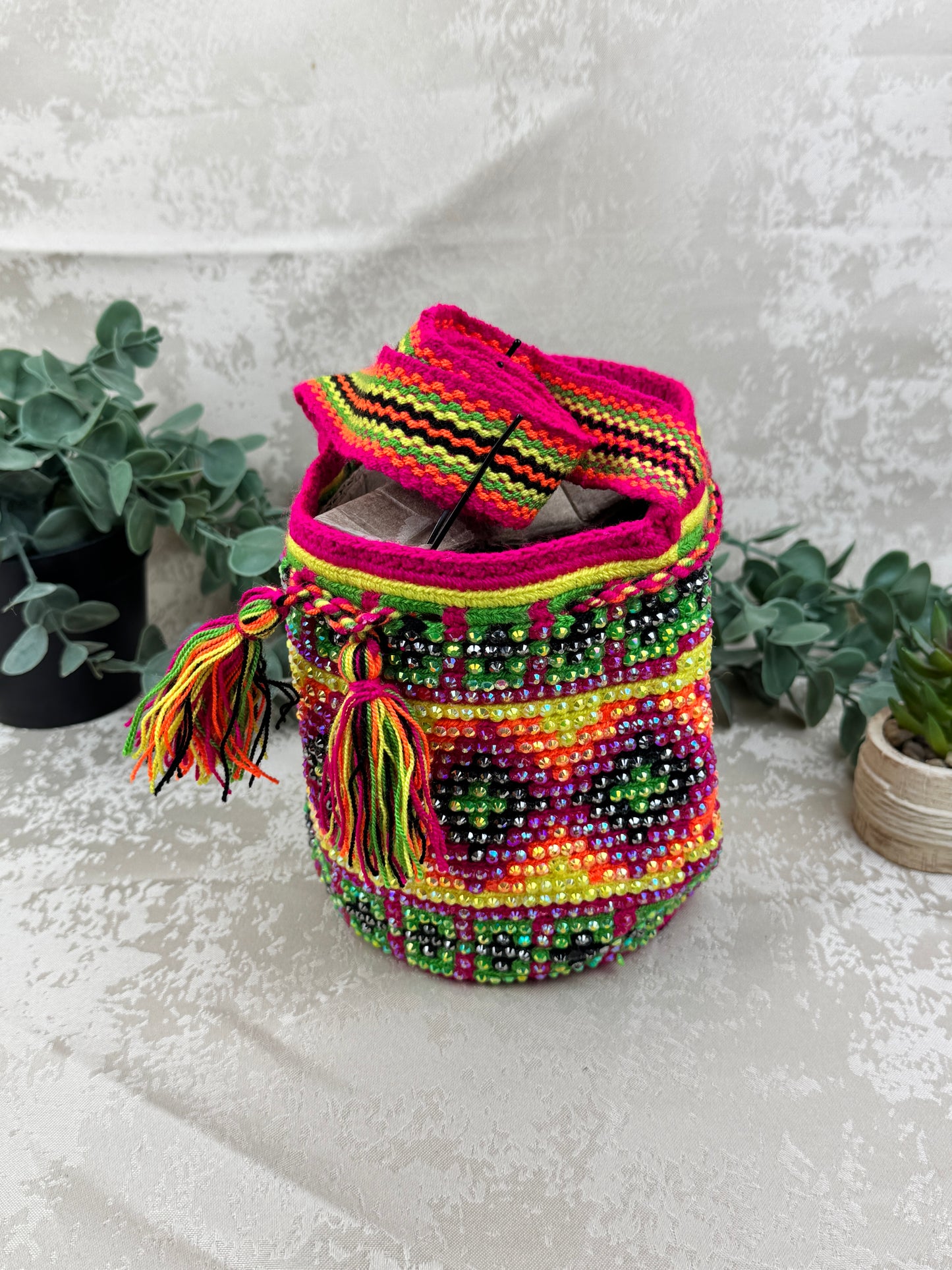 Vista frontal de mochila Wayuu Susuchón edición brillante 9 con piedras decorativas.