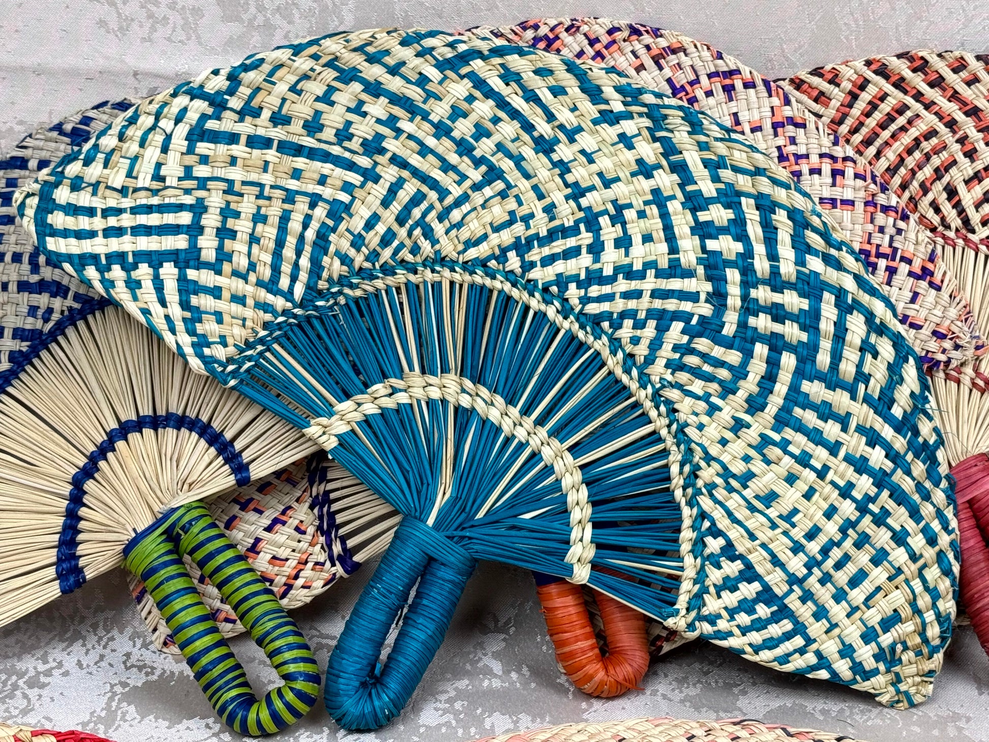 Abanico artesanal de iraca tejido a mano por artesanas colombianas con fibra natural de palma.