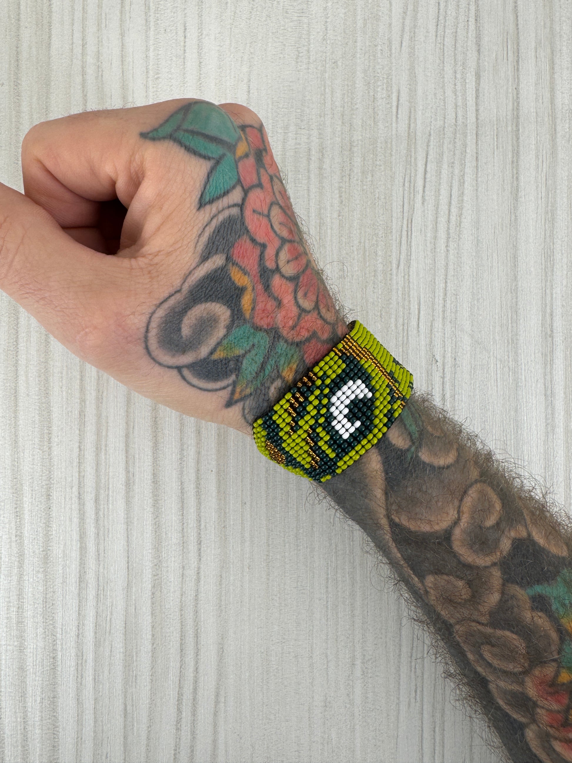 Pulsera de ojo de tigre artesanal usada en muñeca masculina.