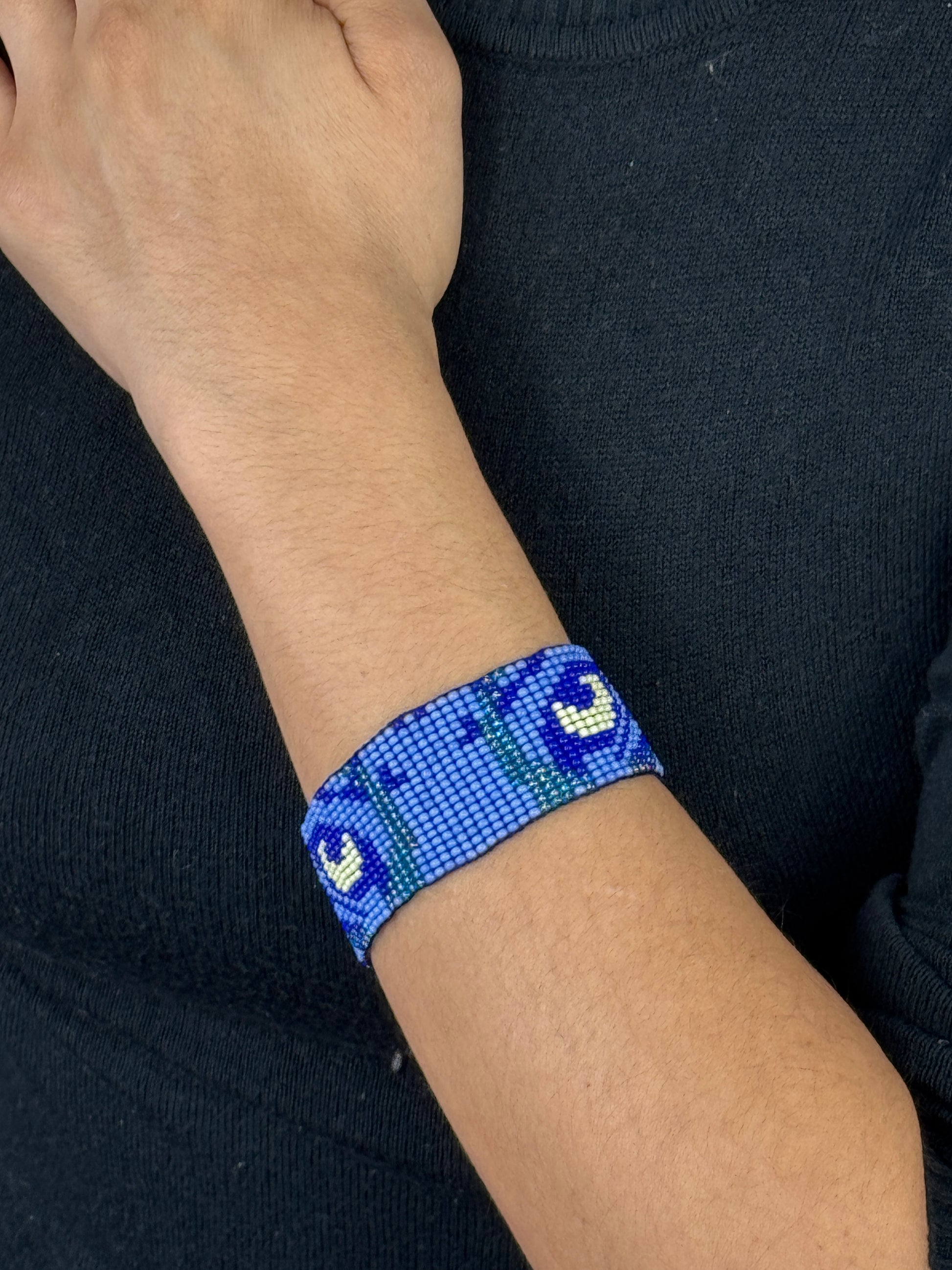 Pulsera artesanal de ojo de tigre en muñeca femenina estilo natural.